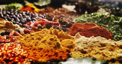 Close -up of a nice composition of spices and spoons on a turning base on bench. Concept: Food, tr