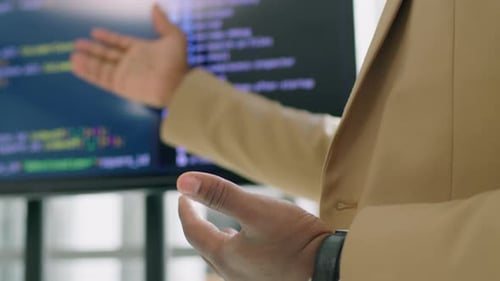 Man Explaining Code on Computer Monitor