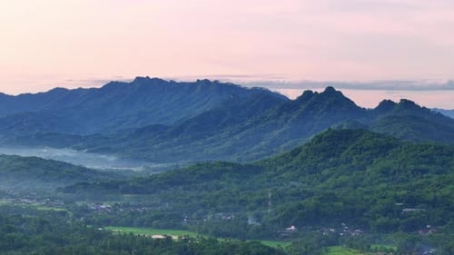 Breathtaking view of forest and mountainous landscape with sunrise sky.