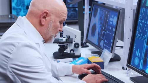 Senior Scientist Working with Microscope and Computers