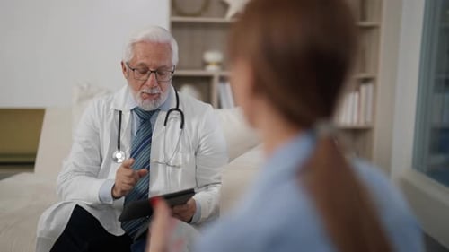 Senior Man Therapist Consults Woman Medical Appointment to Young Patient in Modern Clinic Female Has