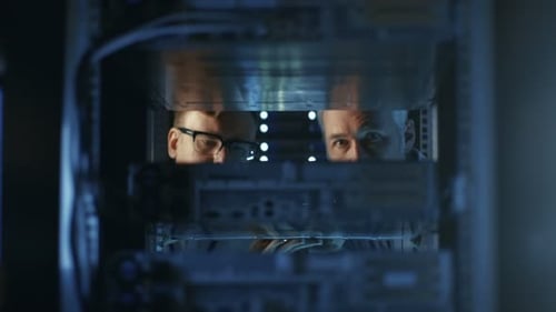 Zwei Servertechniker installieren Hardware im Server-Rack. Sie arbeiten in einem großen modernen Rechenzentrum.