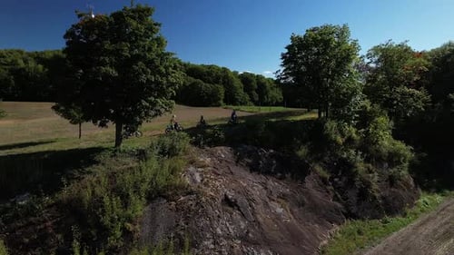 Dirt Bikes Riding Through Countryside on Sunny Day