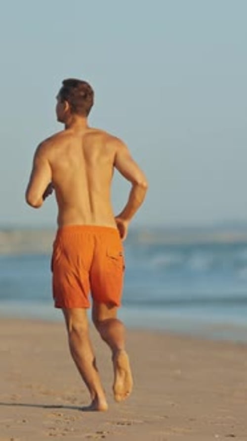 Young Lifeguard Running on the Beach
