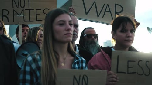 Selective Focus on Young Blonde Woman with Group of Diverse People Protesting Against War