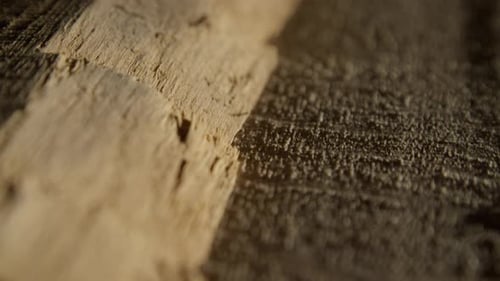 Vidéo de haute qualité montrant une surface en bois en gros plan avec un grain riche, une lumière chaude et une texture subtile