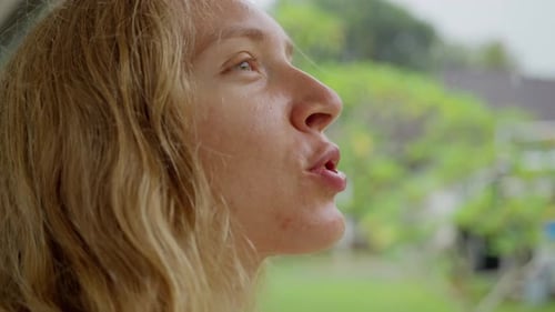 A Woman Standing on the Threshold of the House Waiting for the End of the Rain