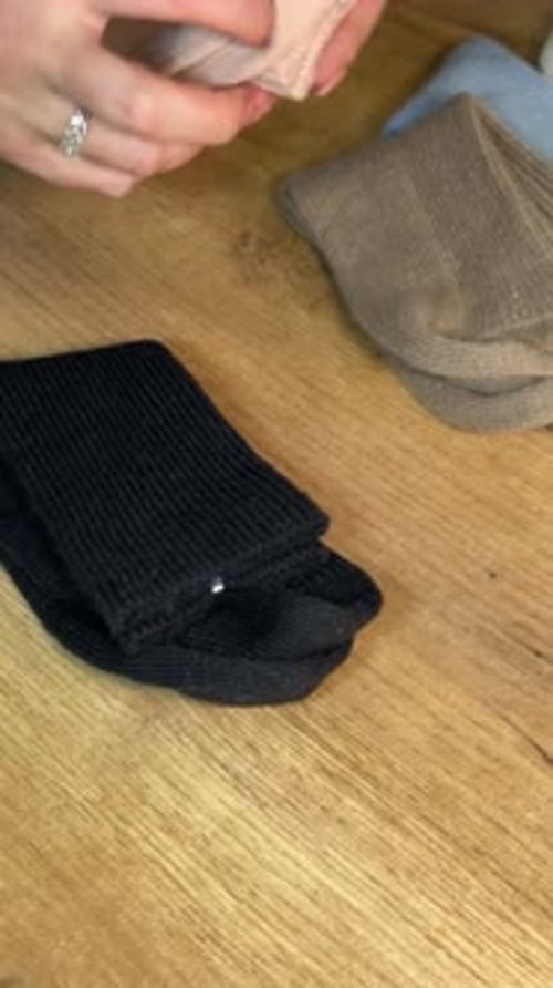 Organizing Socks: Folding and Arranging Clothing on Wooden Table