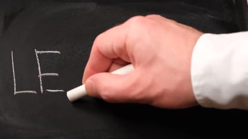 Hand Writes Learning on Chalkboard