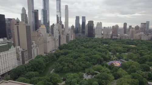 Aerial view of the Central Park and skyscrapers in MIdtown, NYC, USA - panning, tilt, drone shot