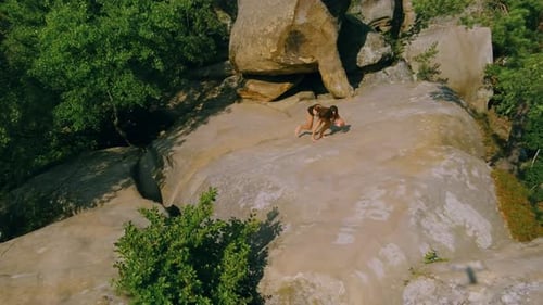 Young Beautiful Sports Lady Training at Dawn on Rocky Terrain