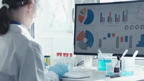 Young Woman Scientist Working at Computer in Lab