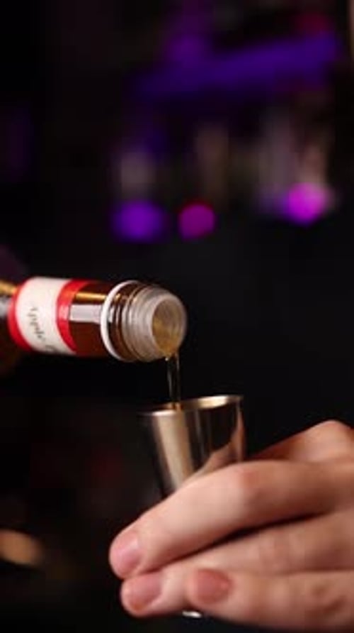 The bartender makes cocktails behind the bar counter.