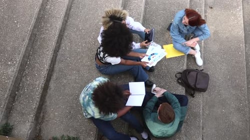 Students Studying Together Outdoors on Concrete Steps
