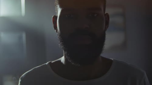 Silhouette eines afroamerikanischen Mannes vor Hintergrundbeleuchtung im schattigen Raum