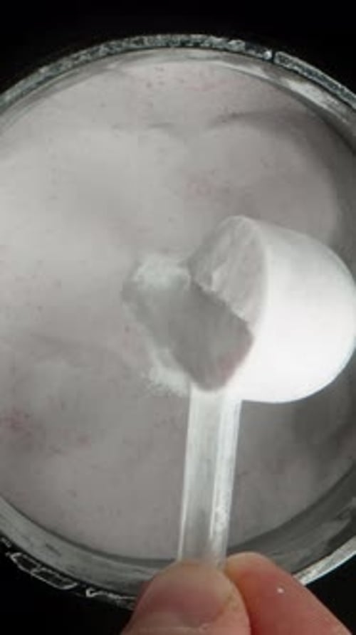 Vertical video. White Powder Poured Back Into The Container From The Measuring Spoon, Concept.
