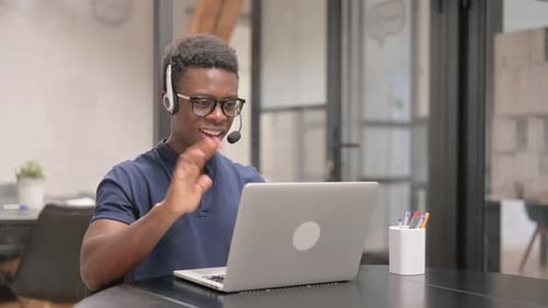 Man on Laptop in Video Call at Office Desk