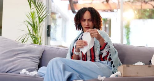 Woman with Cold Blowing Nose on Couch