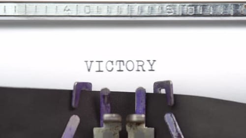 Victory Word Nahaufnahme beim Tippen und zentriert auf einem Blatt Papier auf einem alten Vintage-Schreibmaschinen-Mech