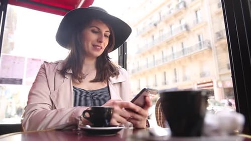 Happy smiling woman enjoying a coffee in a cafe in Paris