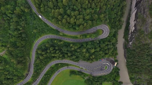Winding Road Through Lush Green Forest Beside a River