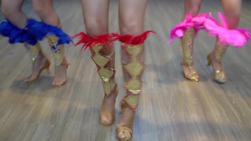 Dancing samba legs close-up, three girls practice dancing samba at the studio wearing show costumes