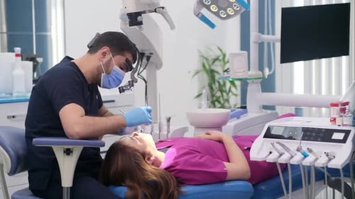 Dental Checkup of Female Patient in Modern Clinic Focused Dentist in Gloves Checking Teeth of Woman