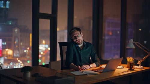 Smiling Specialist Calling Mobile Phone Discussing Agreement at Dark Office