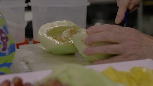Eine Steinmelone für einen Obstsalat schneiden und vorbereiten