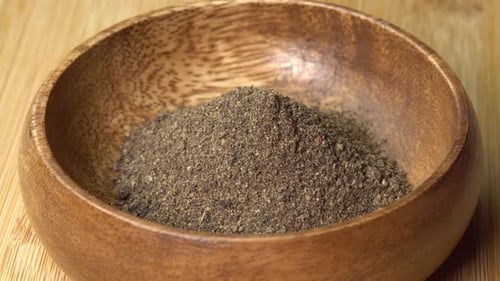 Ground Black Pepper in a Wooden Bowl Close Up