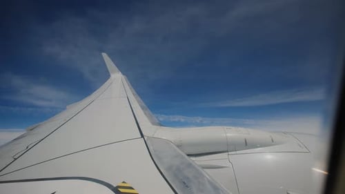 Aircraft Flying in Clouds Airplane Wing and Blue Sky As Seen By Passenger Through Porthole Windows