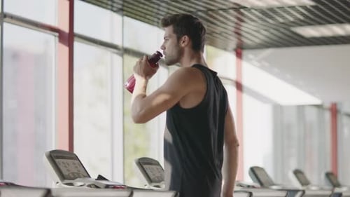 Man Drinks Water at Gym After Workout