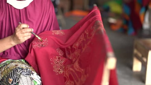 close up, women make batik fabrics in a traditional, flexible way.