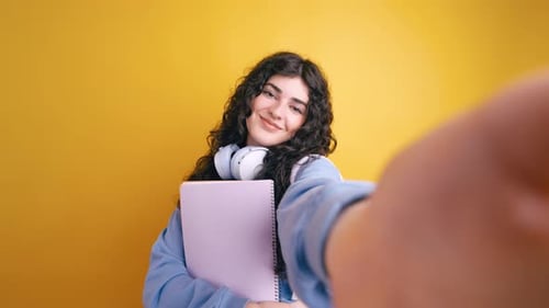 Smiling Woman with Curly Hair Holding Notebook