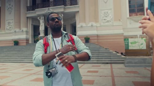 Tourist Poses for Photo in Front of Building