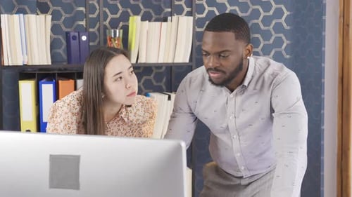 Asian woman and African man working together in the office.