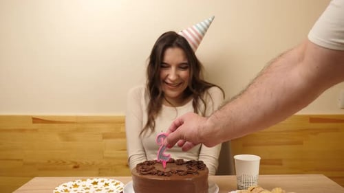 Young Woman Celebrates Birthday with Cake and Candles