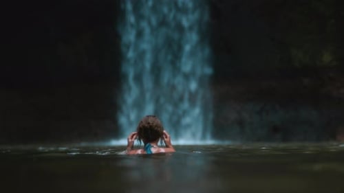 Sexy Girl Gets Up From the Water Near a Waterfall Young Woman Poses in a Lake or River in Bali
