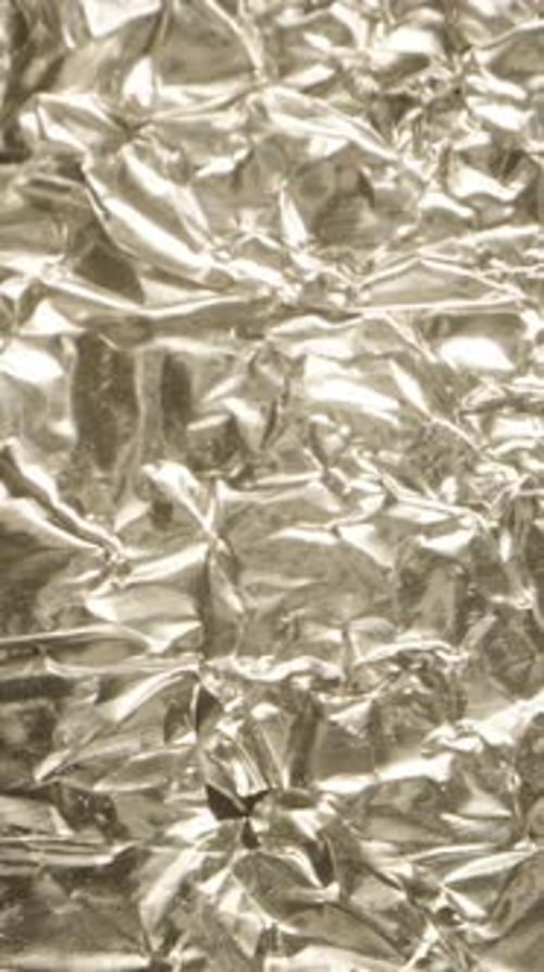 Vertical video. Texture of crumpled silver foil, macro slider.