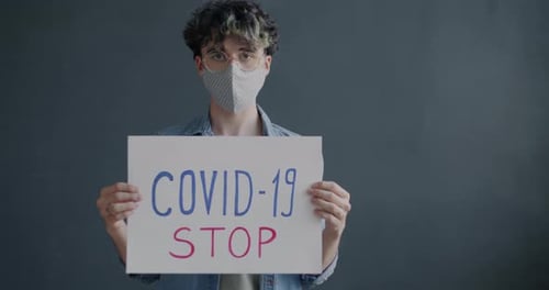 Young Adult Holds COVID-19 Awareness Sign