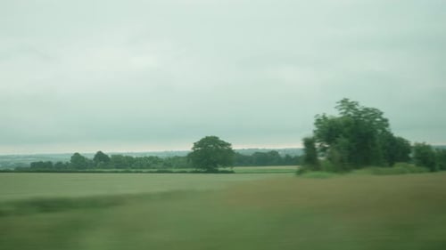 POV-Ansicht aus dem Fenster eines Zuges, der an ländlicher Landschaft in Frankreich vorbeifährt. Folgen Sie Shot