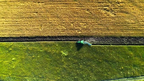 Aerial View of Tractor That Plows Land Preparing Soil for Planting and Cultivating Vegetables or Rye