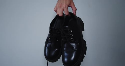 Hand Holds Black Leather Fashion Shoes