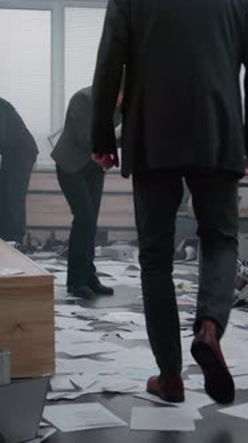 Investigators Examining Scattered Documents in a Modern Office