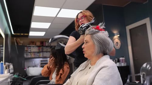 Woman Getting Hair Styled at Salon with Dryer