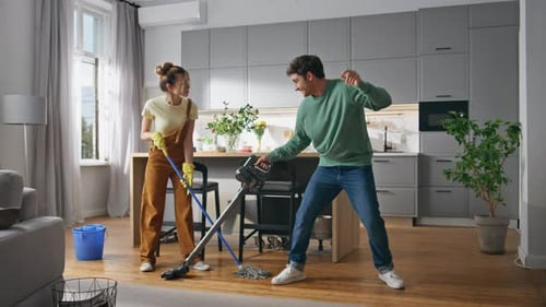 Couple Cleaning Apartment and Dancing with Cleaning Supplies
