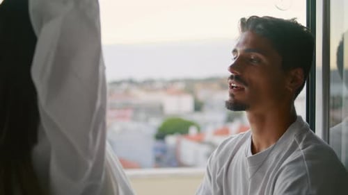 Sensual Couple Embracing Window With City View. Brunette Man Twirling Cute Woman In Tender Dance....