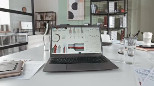 Wireless Laptop with Diagrams and Charts on Screen on Office Desk