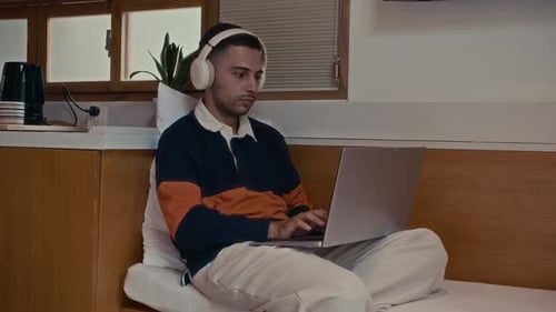 Entrepreneur in Headphones Working on Laptop at Home Office