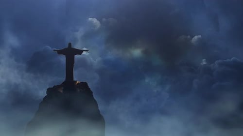jesus statue on the mountain with thunderstorm background